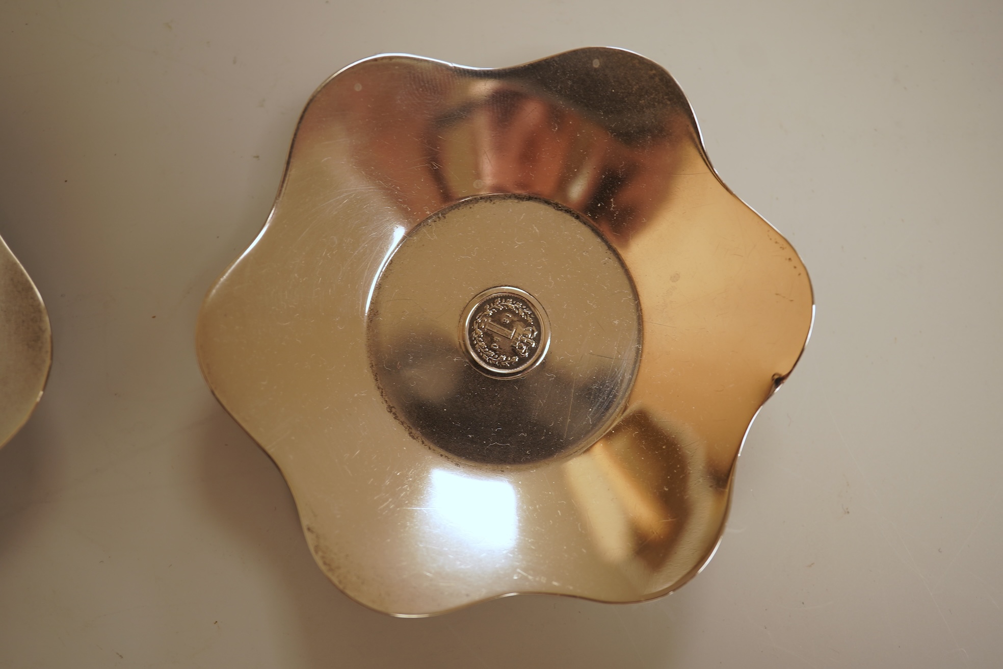 A cased set of four George V silver flower head shaped nut dishes, each inset with an 1850 maundy coin, Walker & Hall, Birmingham, 1936, diameter 77mm.